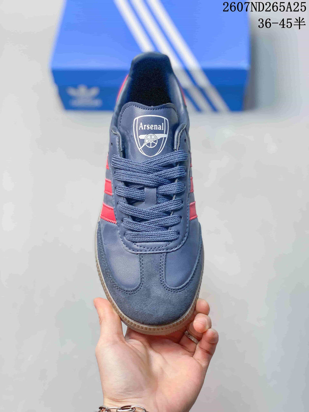 Top view showing the rounded toe, navy laces, tongue label, red side stripes, and Arsenal crest.