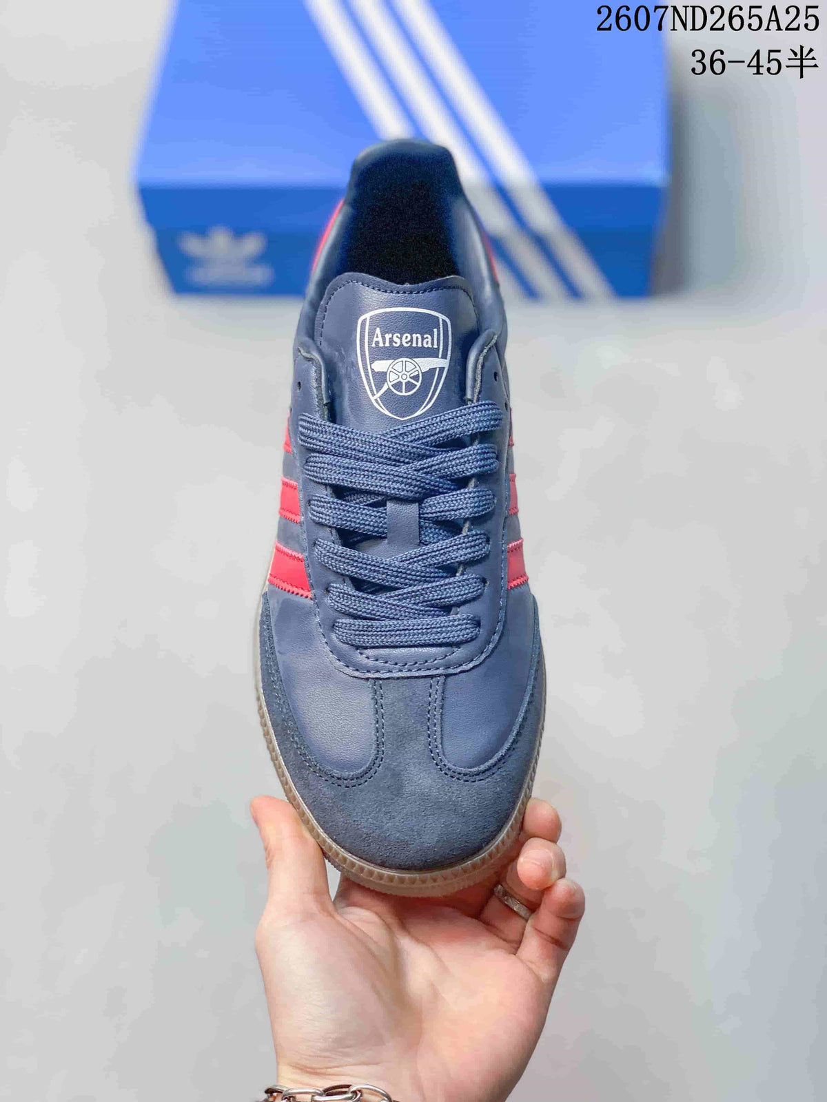 Top view showing the rounded toe, navy laces, tongue label, red side stripes, and Arsenal crest.