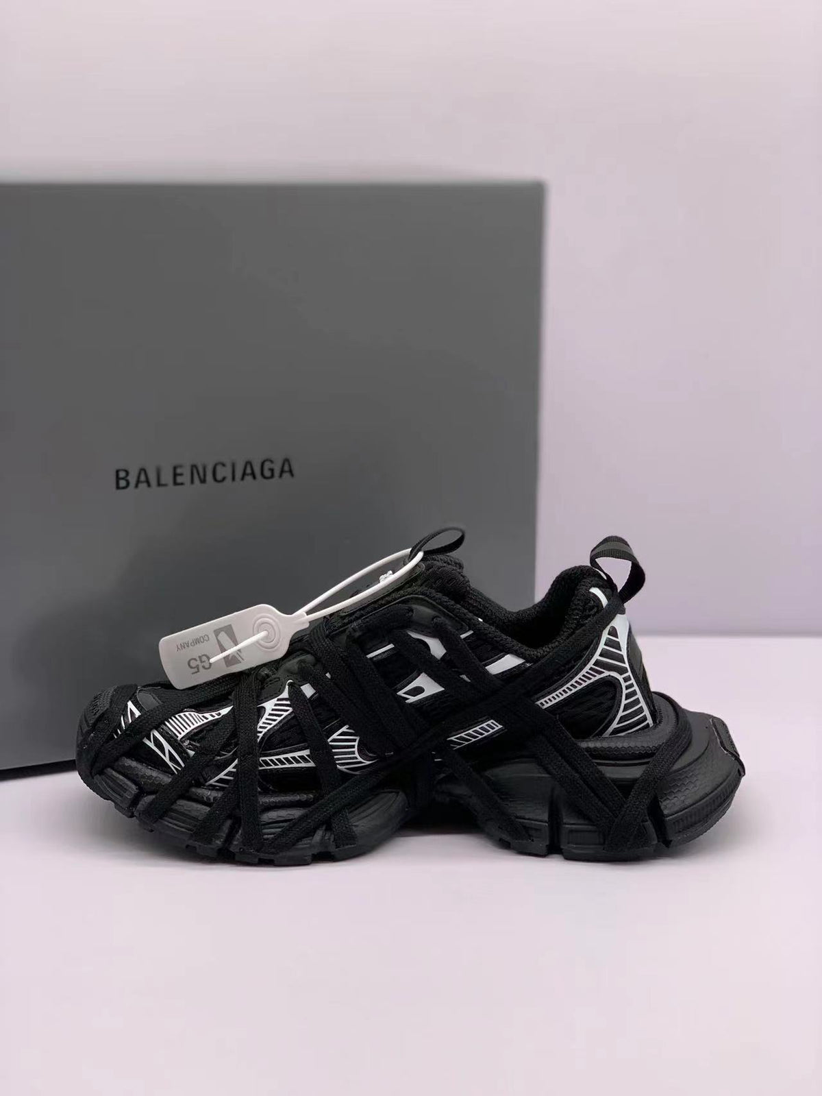 Rear-side view of black and white Balenciaga 3XL sneakers showing layered panels and pull tabs.