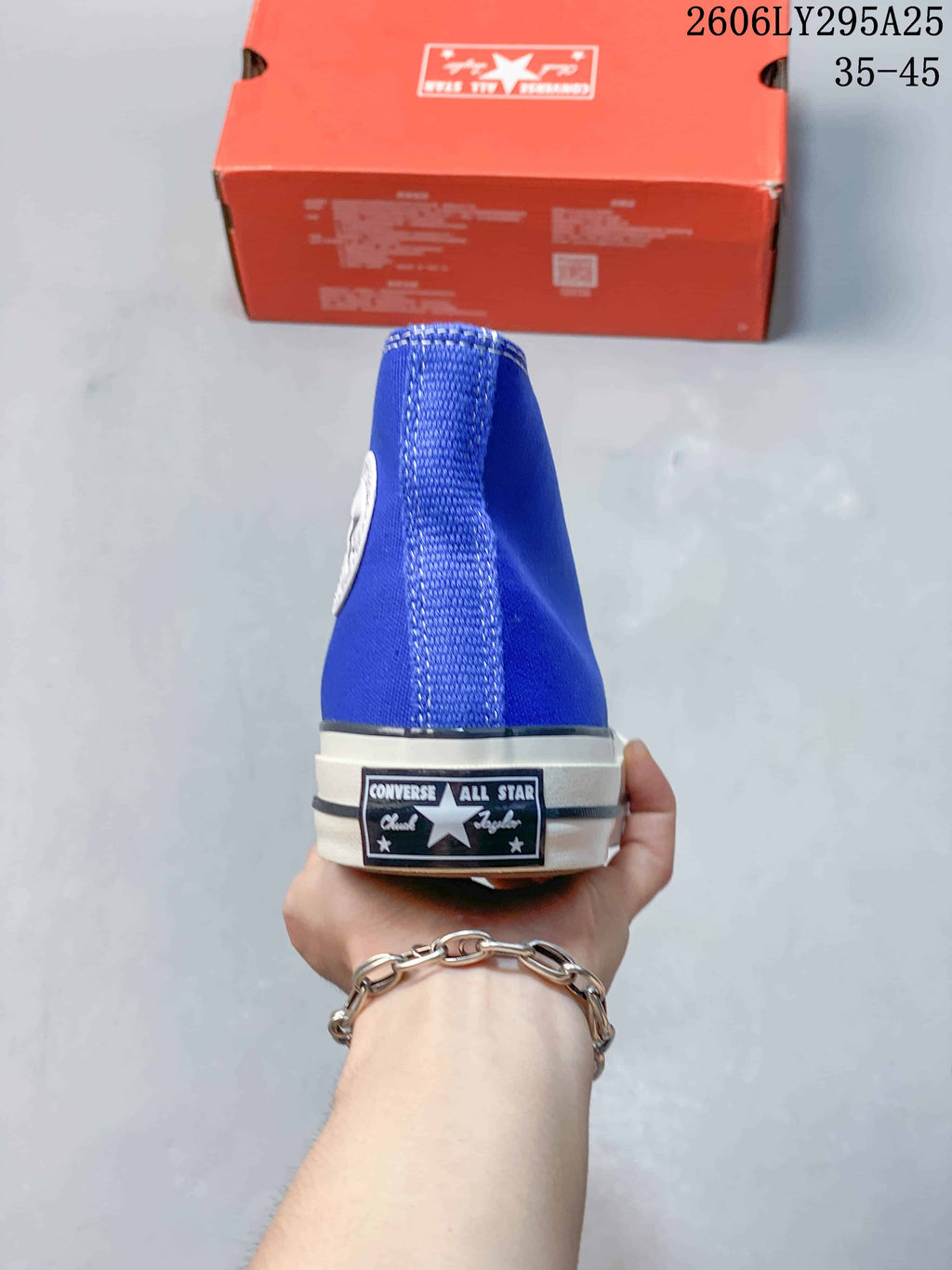 Rear view of the blue high-top sneaker showing the Converse All Star heel label and white midsole.
