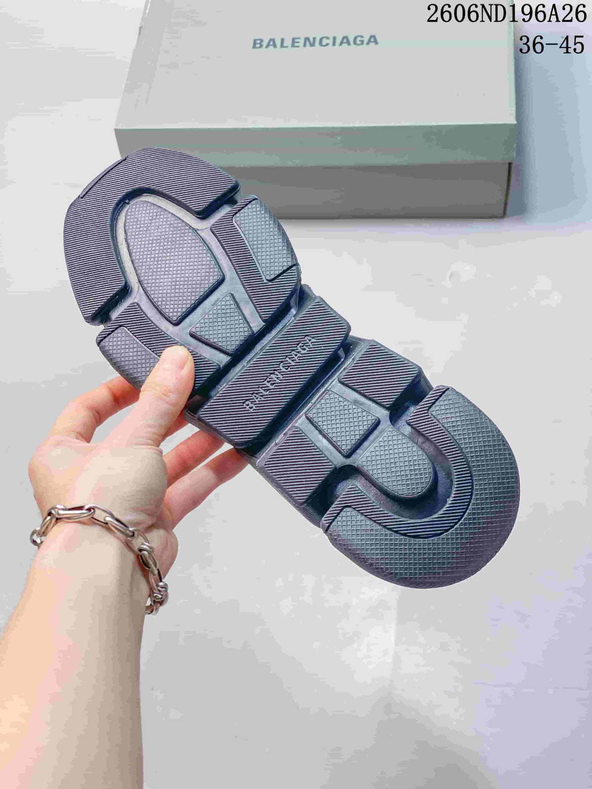Underside view of a dark gray sneaker showing the segmented, textured outsole and Balenciaga branding.