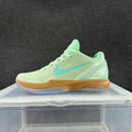 Side view of a mint-green Nike basketball shoe with a turquoise Swoosh, gum-colored midsole and translucent outsole.