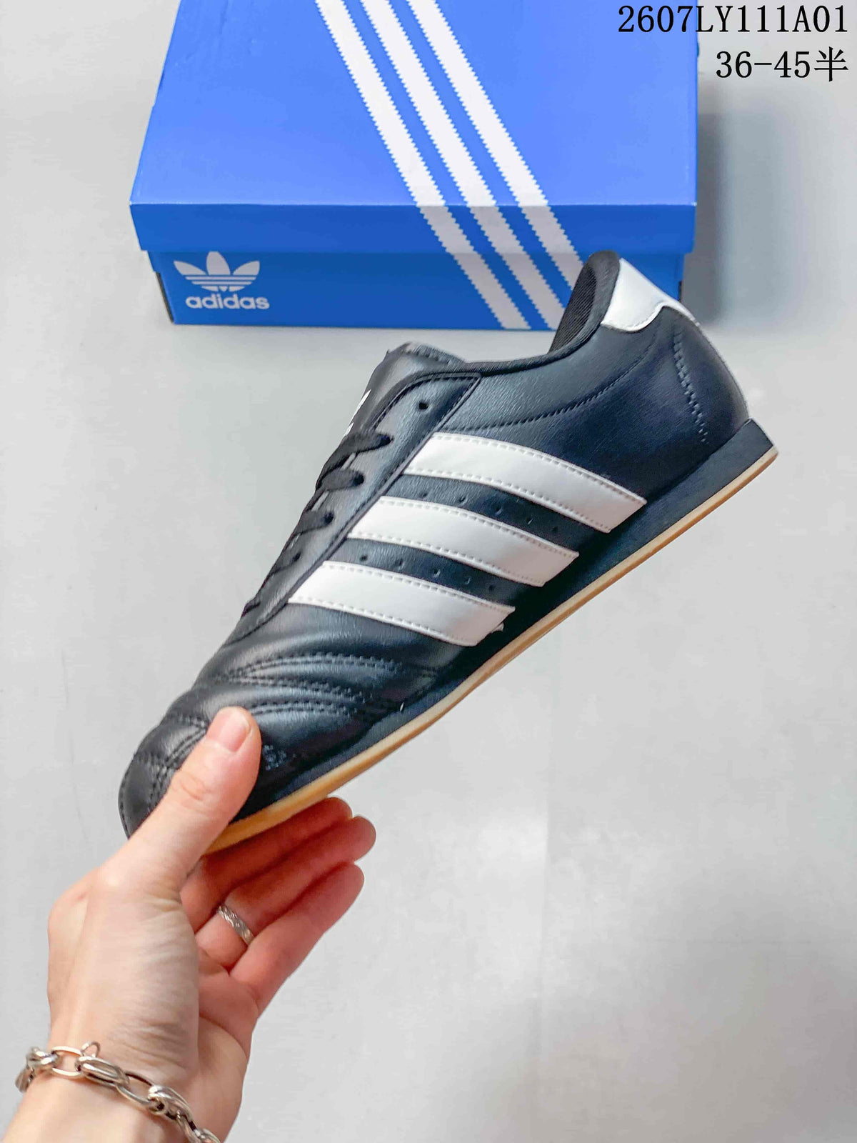 Side view of the dark gray sneaker with white stripes and a gum-colored outsole