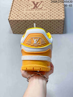 Rear view of a white Trainer Maxi sneaker showing its orange heel panel and yellow outsole.