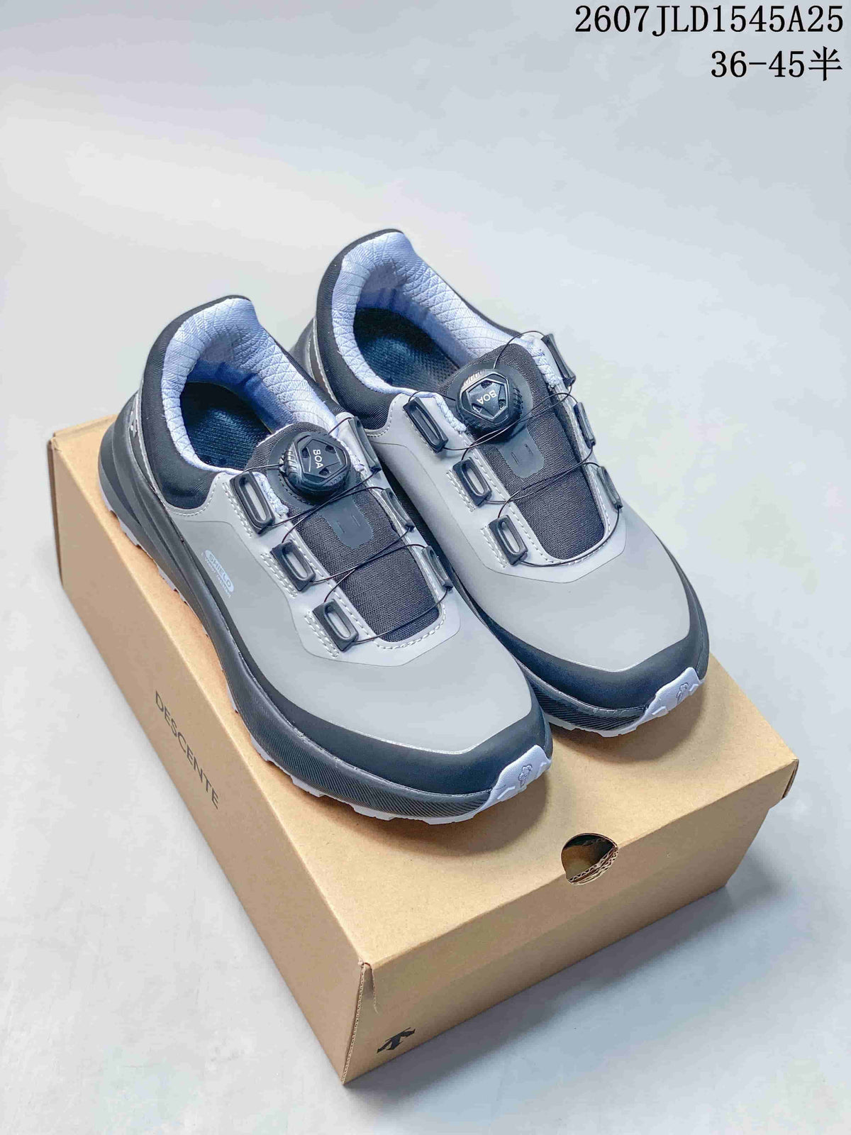 Pair of gray and black DESCENTE SHIELD Mantrix sneakers displayed on a shoebox, with the model code and size range printed above.