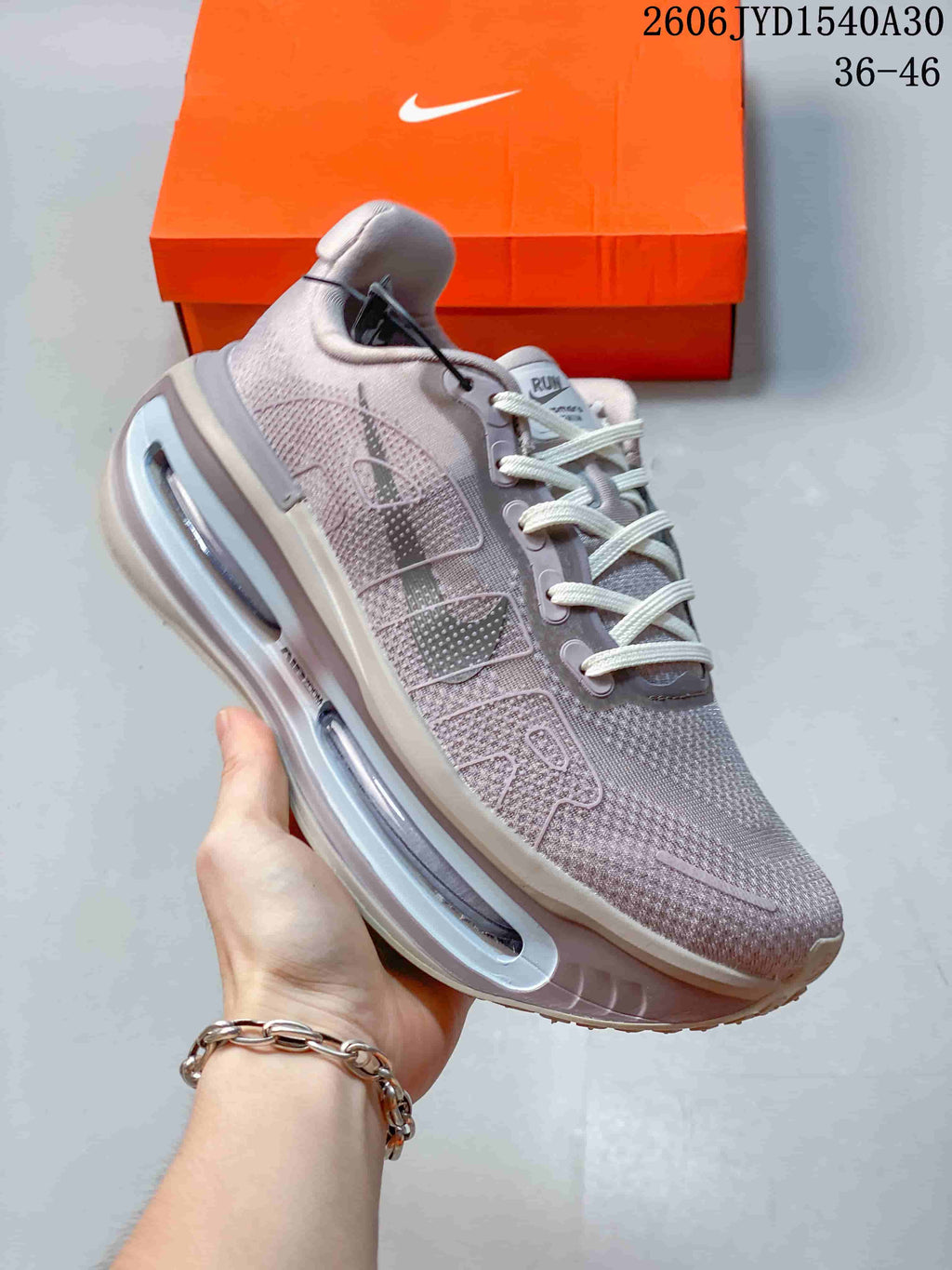 Angled side view of a mauve-gray Nike sneaker with white laces and a sculpted sole