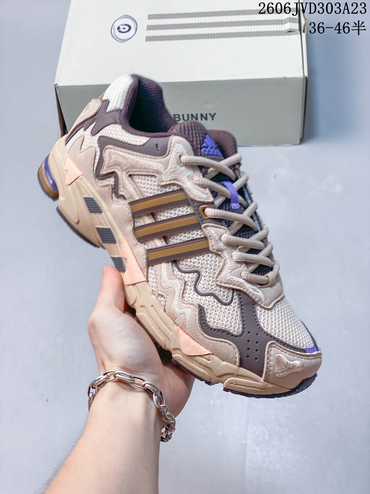 Angled side view of the beige and taupe sneaker with purple details