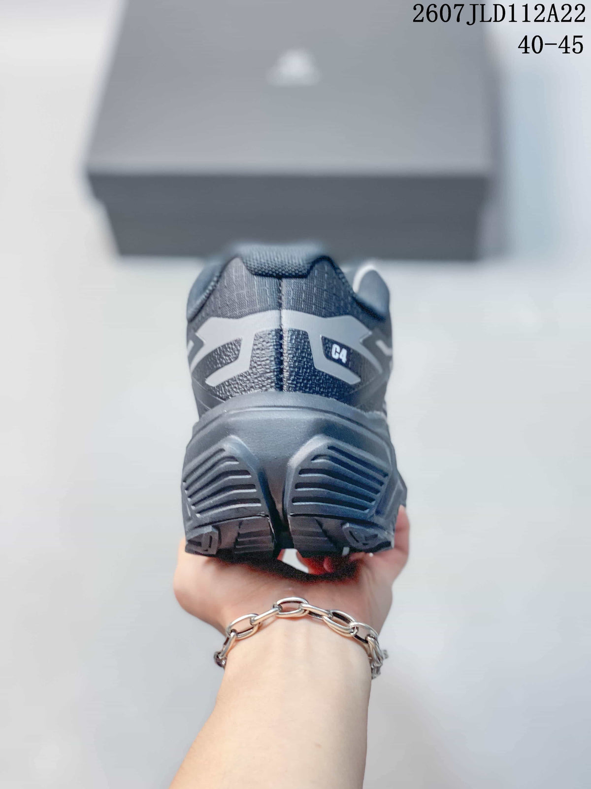 Rear view of the dark gray shoe showing the padded collar, heel structure, and outsole grooves; code 2607JLD112A22 and size range 40–45 are overlaid.