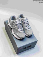 Pair of grey and silver New Balance 740 sneakers displayed on a shoebox.