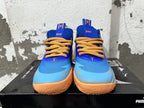 Front view of blue and light blue Puma Melo basketball shoes with yellow-orange laces and sole accents.