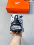 Rear view of the white and black sneaker showing the padded heel, Nike branding, and sculpted outsole.