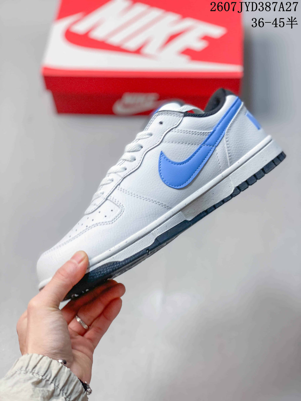 Side profile highlighting the blue Swoosh, white upper and dark outsole.