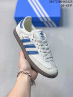 Angled side view of a white and blue Adidas Samba sneaker with visible Samba side branding.