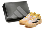 Yellow Adidas Adizero shoes and a dark shoebox
