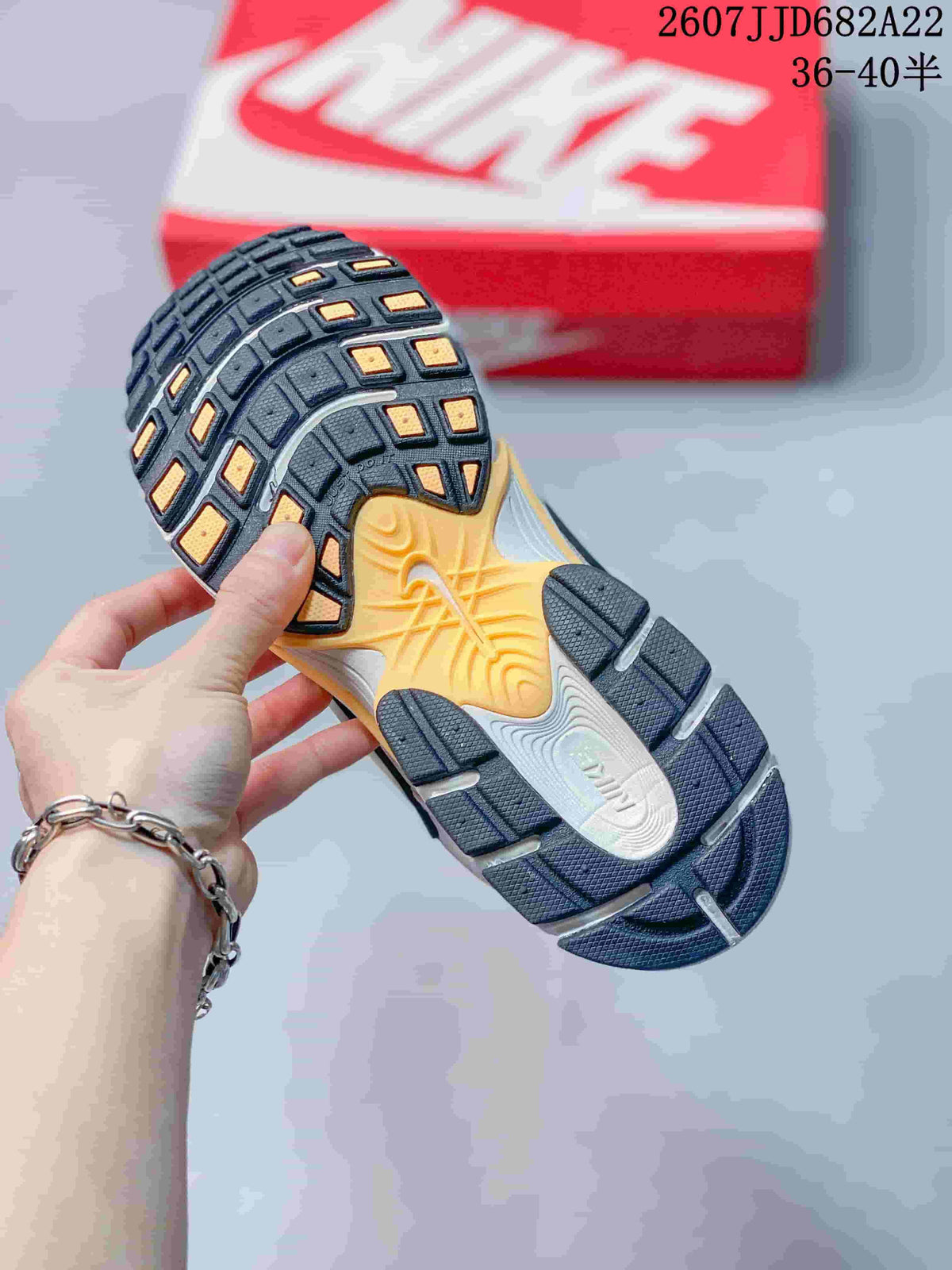 Underside view of the sneaker showing the black, gray and yellow patterned rubber outsole; image text shows style code 2607JJD682A22 and size range 36–40.