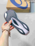 View of the patterned black and gray rubber outsole on a purple ASICS running shoe.