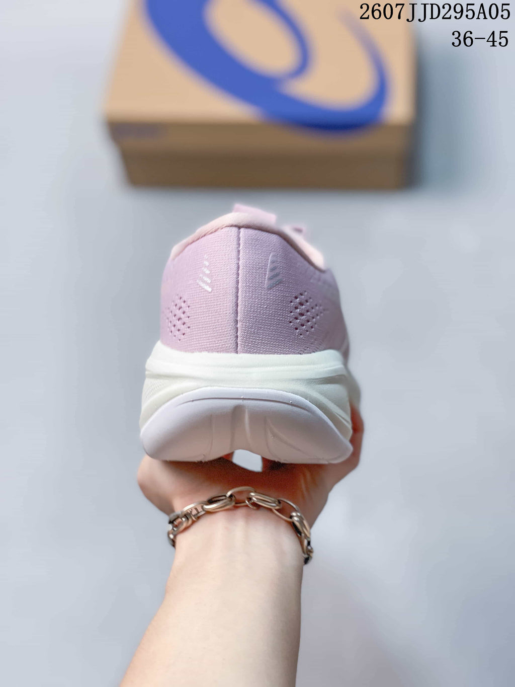 Rear view of the pink sneaker showing the padded heel collar, heel ventilation details, and white outsole.