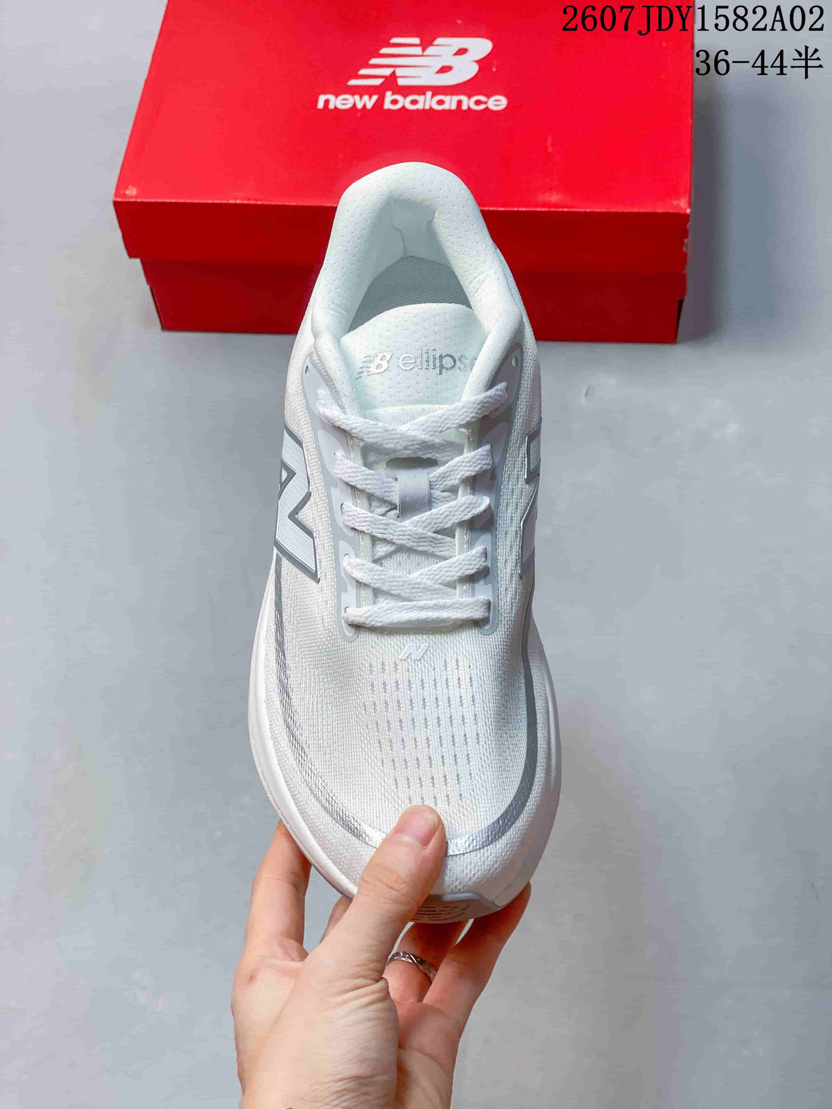Top view of a white lace-up New Balance running shoe with silver accents.
