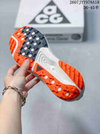 Close view of the Nike ACG Pegasus Trail outsole showing black and orange sections with a lugged tread pattern.
