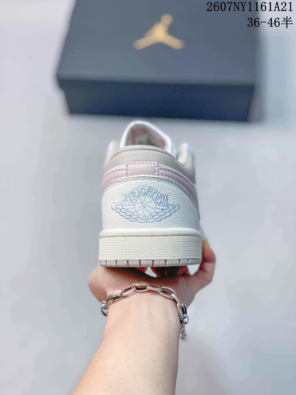 Rear view showing the embroidered Jordan Wings logo, pink heel accent and textured outsole edge.