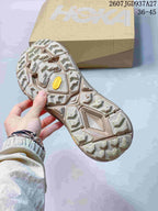 Underside view of a SATISFY sneaker showing the patterned lugged outsole and a yellow outsole insert.