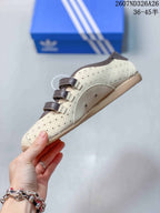 Side view showing the cream perforated upper, brown strap closures and textured outsole.