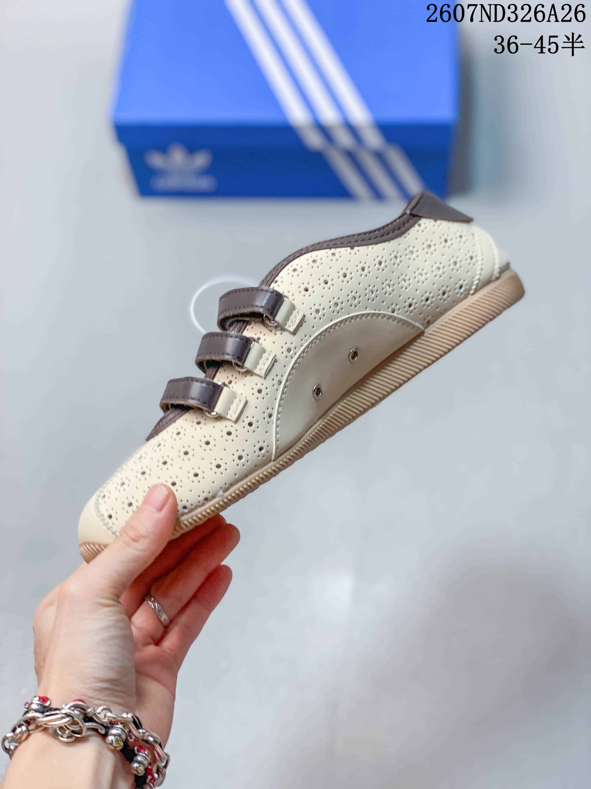 Side view showing the cream perforated upper, brown strap closures and textured outsole.