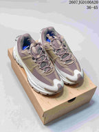Pair of taupe-gray and white Nike Zoom Vomero Roam sneakers displayed on a shoebox, with the style code and size range visible above.