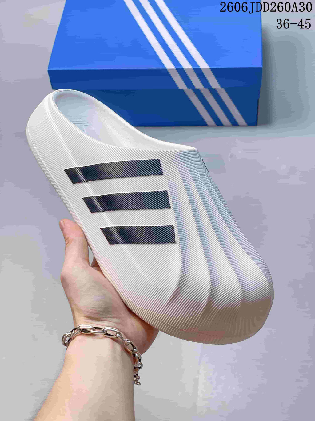 Close-up of the white adiFOM Superstar mule showing its ridged closed toe and dark stripes.