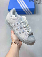 Angled side view showing the shell toe, textured three stripes, and Superstar marking.