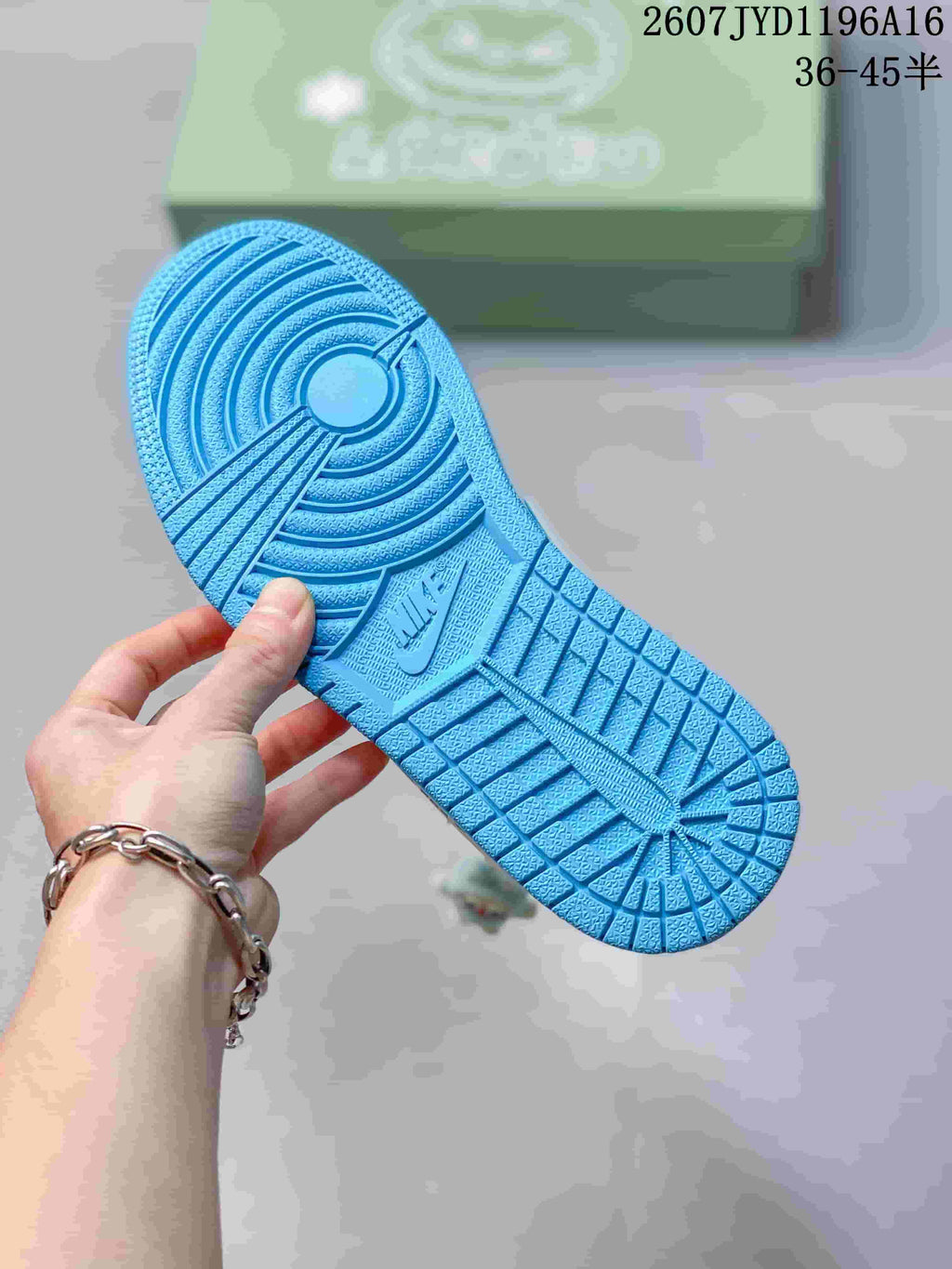 Blue rubber outsole of the sneaker showing circular and geometric traction patterns, with a Nike mark in the center area.