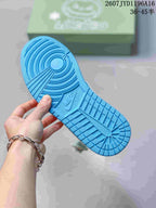 Blue rubber outsole of the sneaker showing circular and geometric traction patterns, with a Nike mark in the center area.