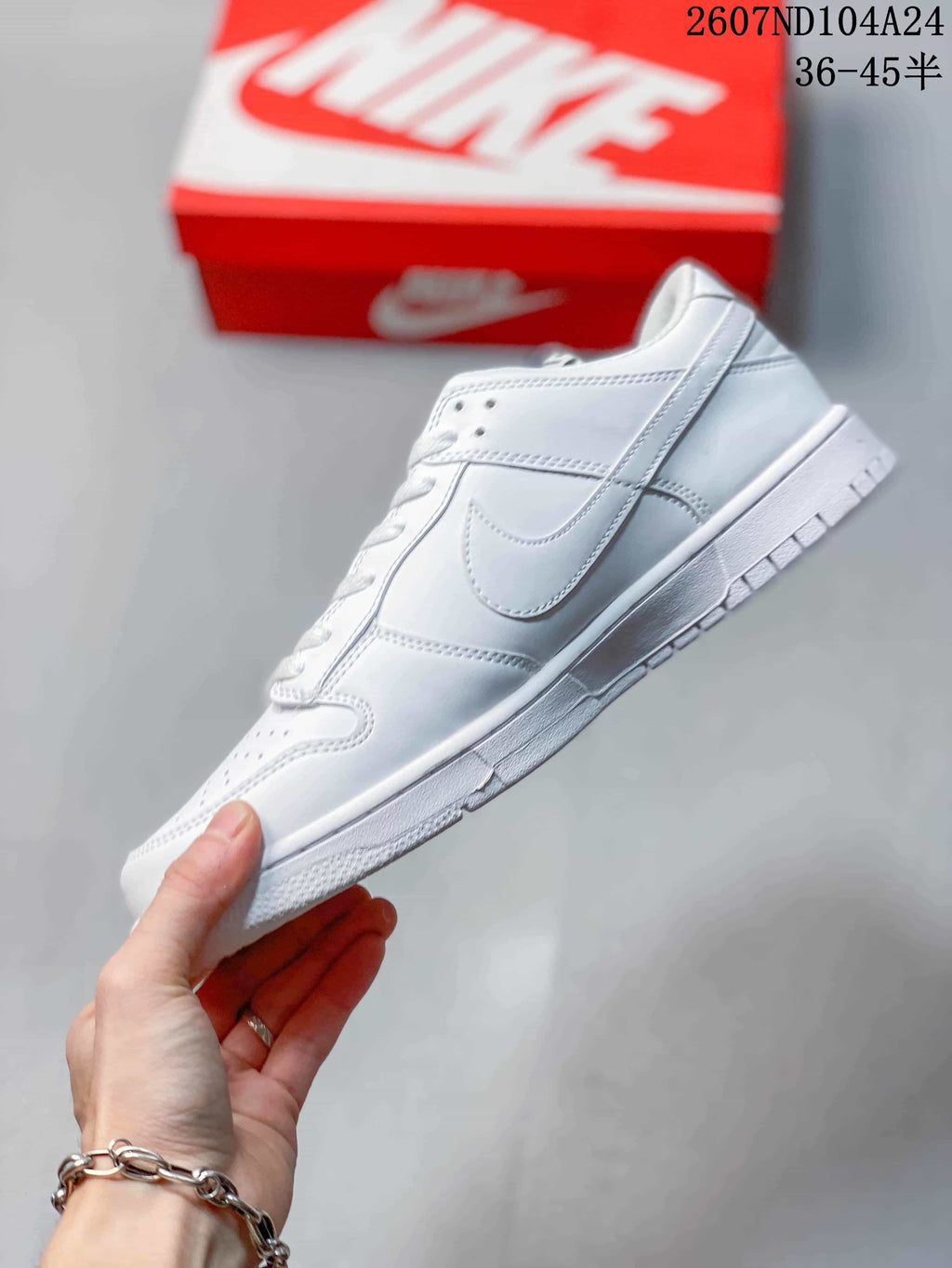 Side profile of a white Nike low-top sneaker with Swoosh detailing and stitched panels.