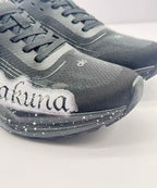 Close-up of the black textured toe box, laces, white lettering and speckled midsole.