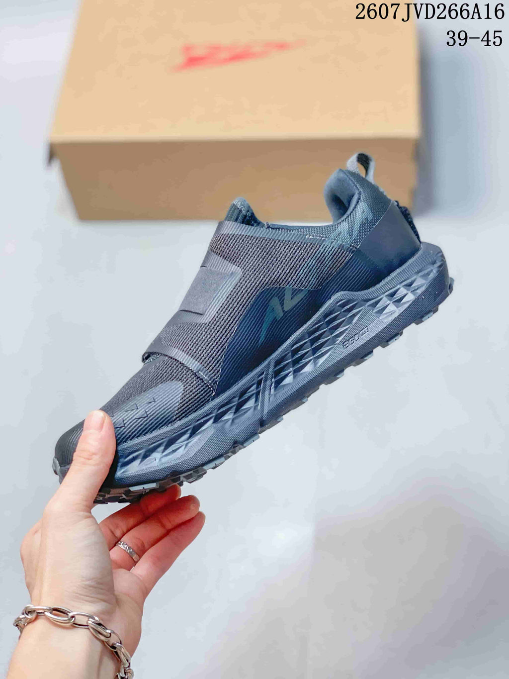 Side profile showing the dark gray upper, layered straps, BOA dial closure, textured midsole, and trail outsole.