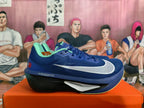Side view of a blue Nike ZoomX running shoe with a white Swoosh and dark sole.