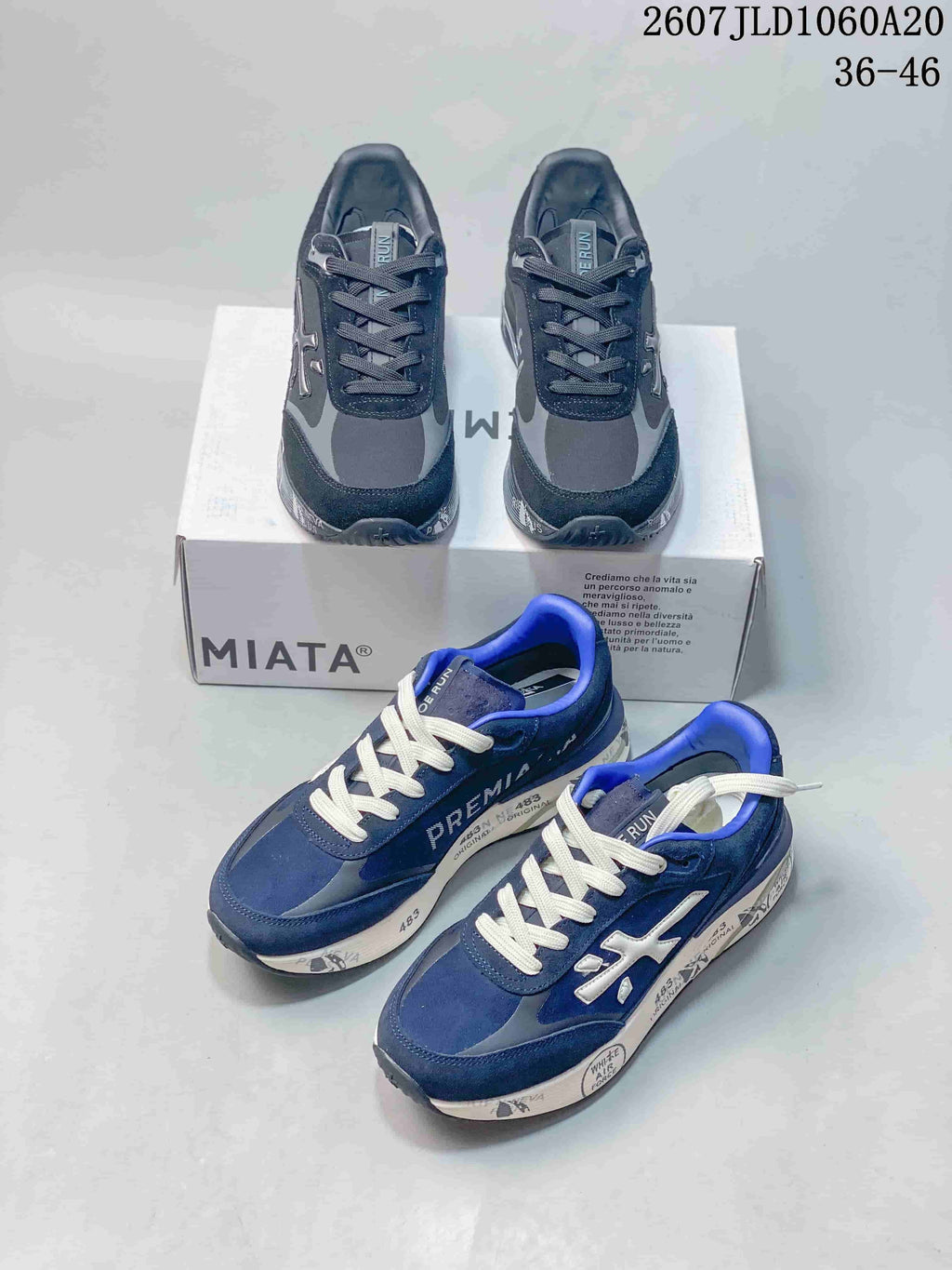 Navy and black Premiata Lander trainers arranged around a shoebox, showing both colorways and the low-top silhouette.