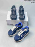 Navy and black Premiata Lander trainers arranged around a shoebox, showing both colorways and the low-top silhouette.