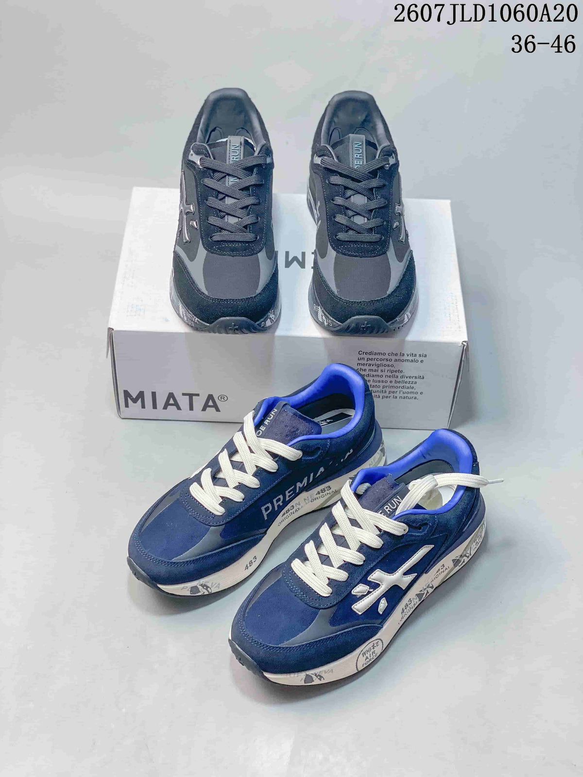 Navy and black Premiata Lander trainers arranged around a shoebox, showing both colorways and the low-top silhouette.