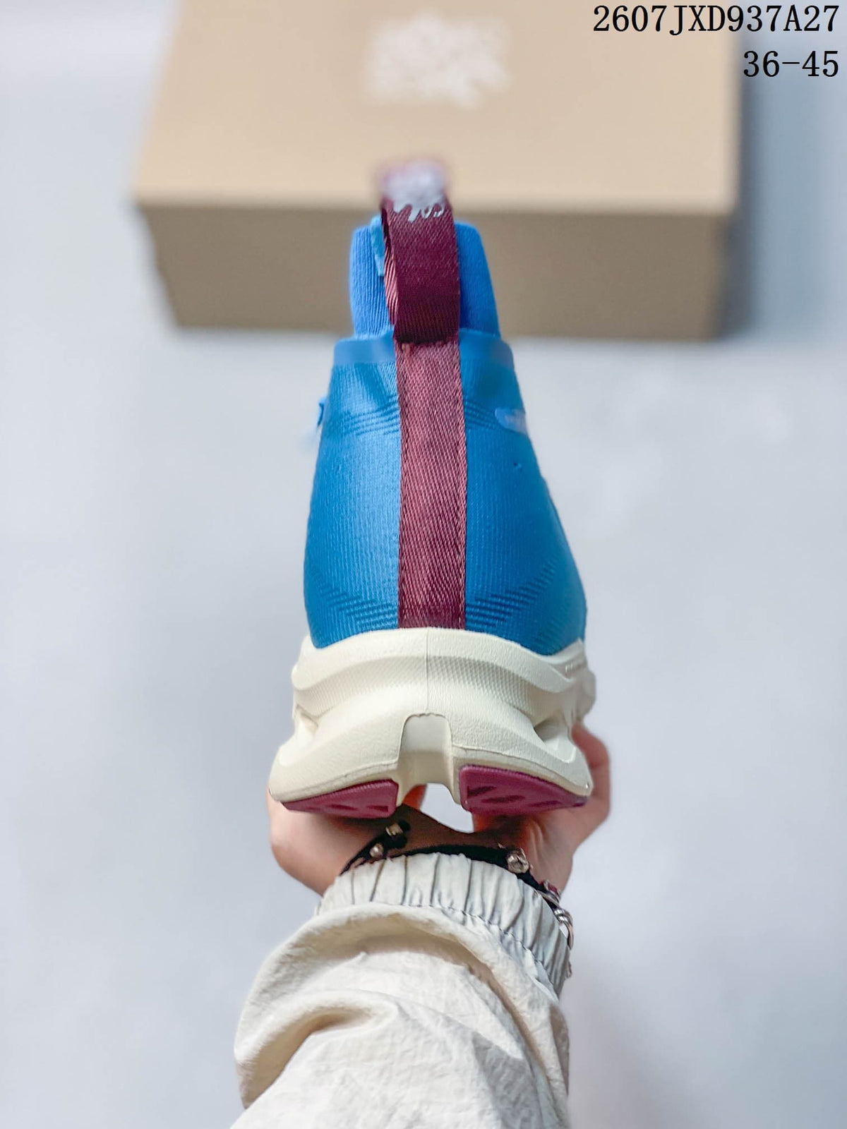 Rear view of a blue high-top sneaker showing the burgundy center heel pull tab and white sole.