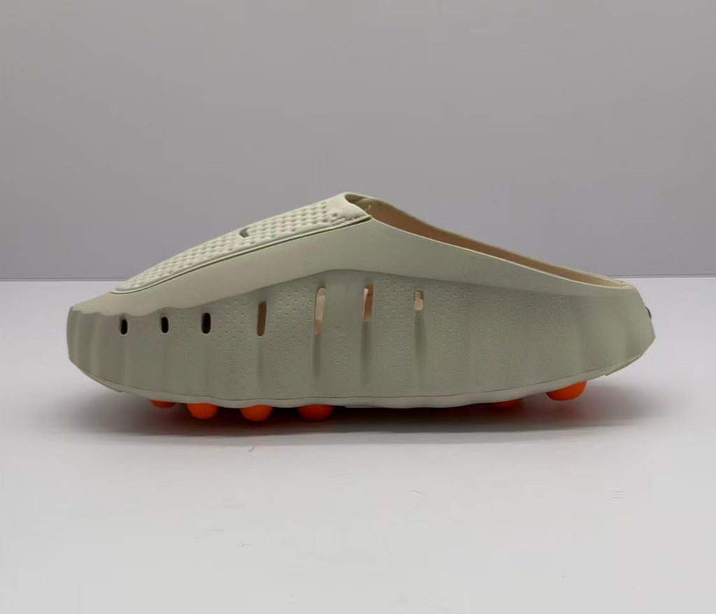 Side view showing perforated openings along the beige sandal upper and orange circular outsole elements.