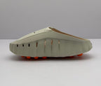 Side view showing perforated openings along the beige sandal upper and orange circular outsole elements.