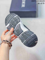 Bottom view of a black and white Dior sneaker showing the segmented rubber outsole and branded heel insert.