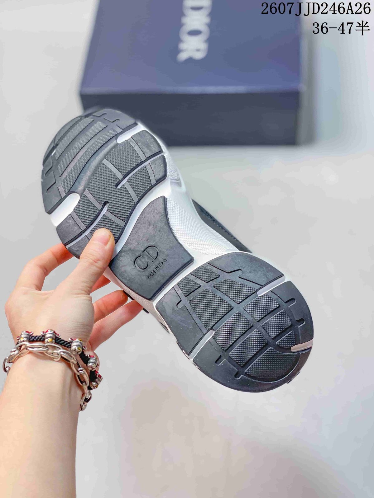 Bottom view of a black and white Dior sneaker showing the segmented rubber outsole and branded heel insert.