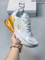 Angled side view of the white and gold Nike Air Max 270 sneaker with visible heel cushioning unit.