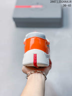 Rear view of the orange and gray sneaker showing the padded heel, textured gray panel, and red branding strip.