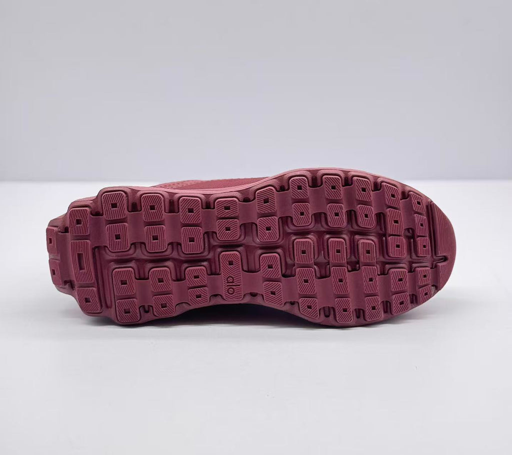 Underside view showing the burgundy patterned rubber outsole with segmented traction blocks.