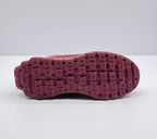 Underside view showing the burgundy patterned rubber outsole with segmented traction blocks.
