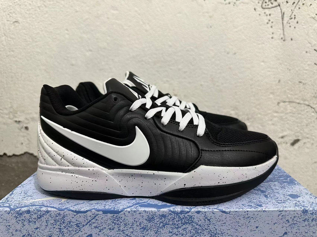 Side view of a black basketball shoe with white Swoosh detailing and a speckled midsole