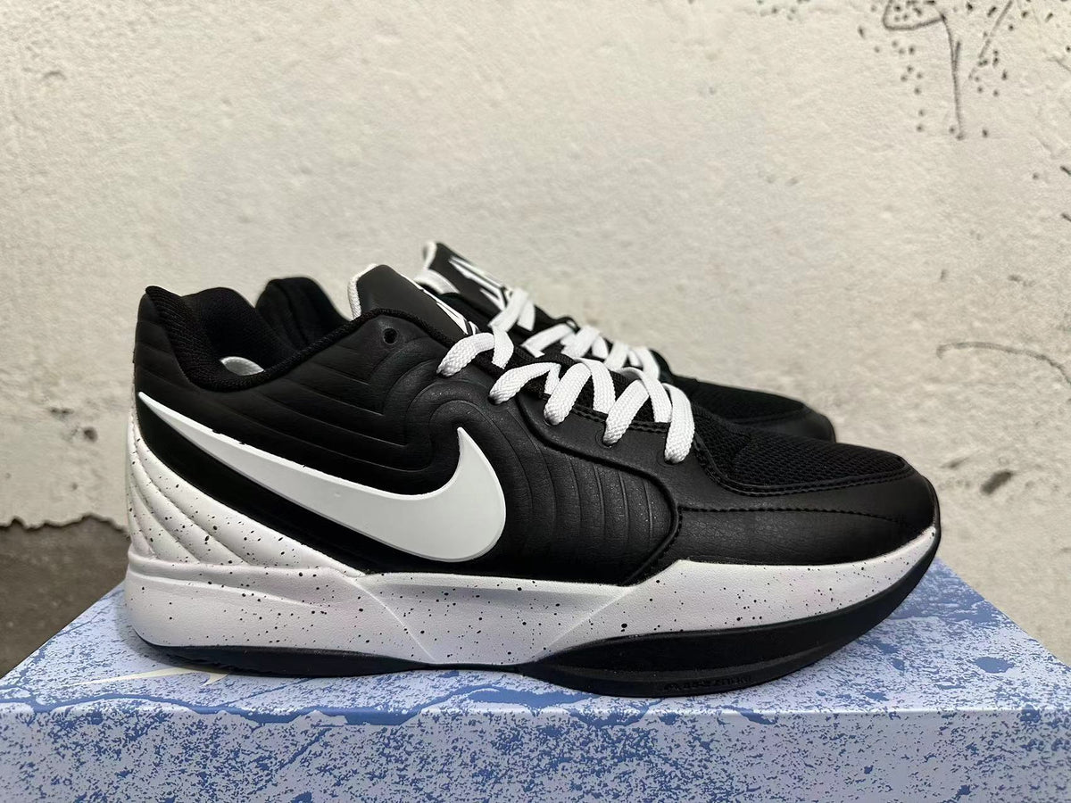 Side view of a black basketball shoe with white Swoosh detailing and a speckled midsole